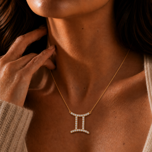 Gold necklace with a Gemini symbol pendant on a person's neck.