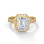 Gold ring with emerald-cut diamond and smaller diamonds on a white background