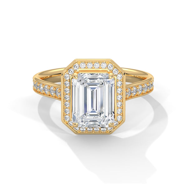 Gold ring with emerald-cut diamond and smaller diamonds on a white background
