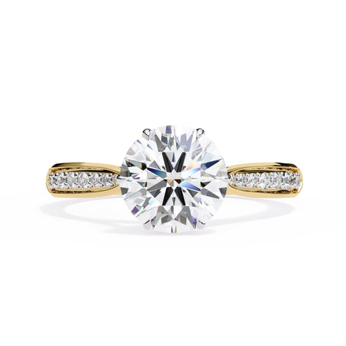 Gold ring with a large diamond and smaller diamonds on the band against a white background