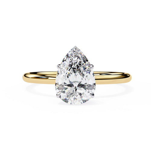 Gold ring with a pear-shaped diamond on a white background