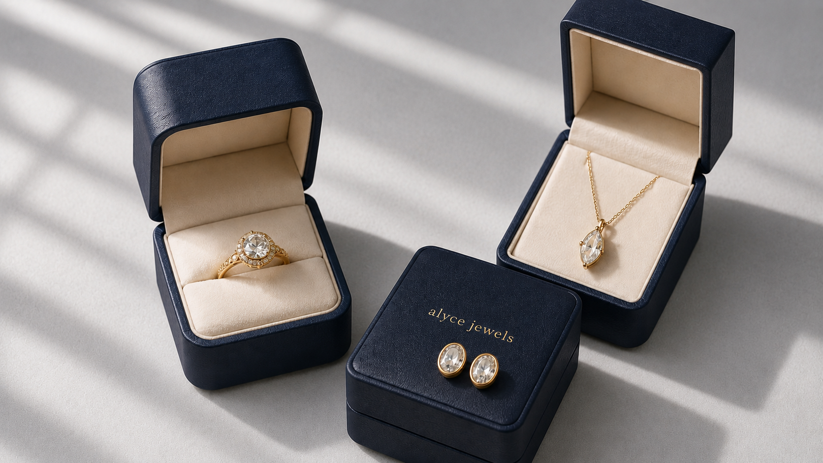 Jewelry set including a ring, necklace, and earrings in open navy blue boxes on a light background.