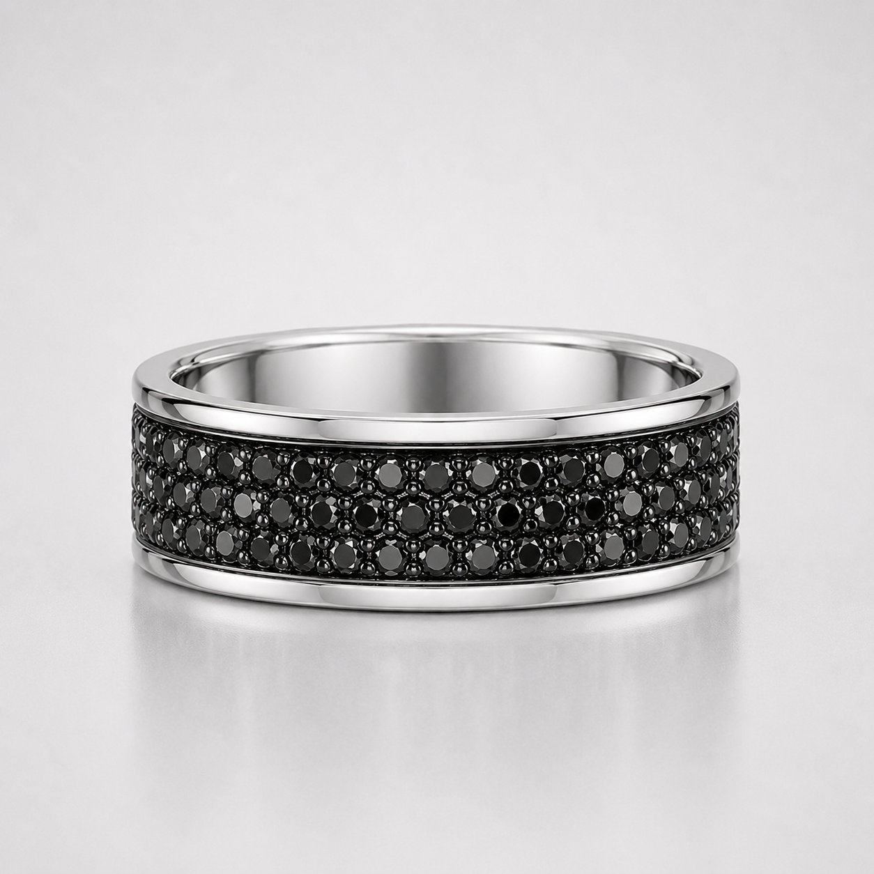 Silver ring with black gemstones on a light gray background