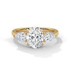 Gold ring with a heart-shaped diamond and two pear-shaped diamonds on a white background