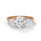 Rose gold ring with a large diamond and smaller pear-shaped diamonds on a white background