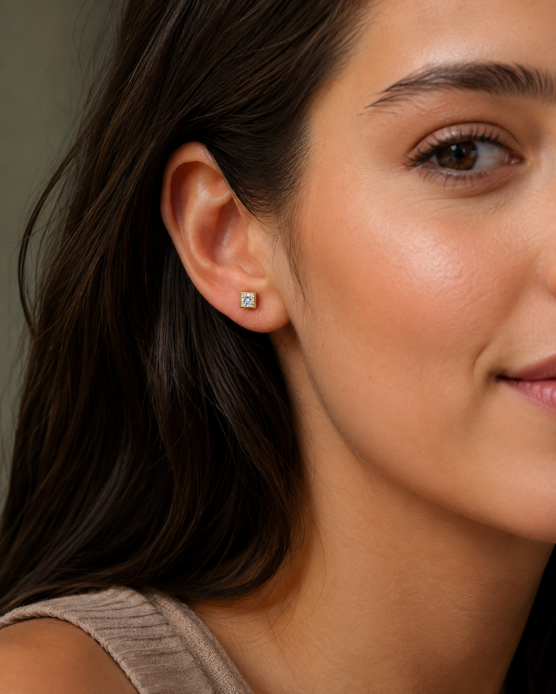 Close-up of a woman wearing a diamond stud earring.