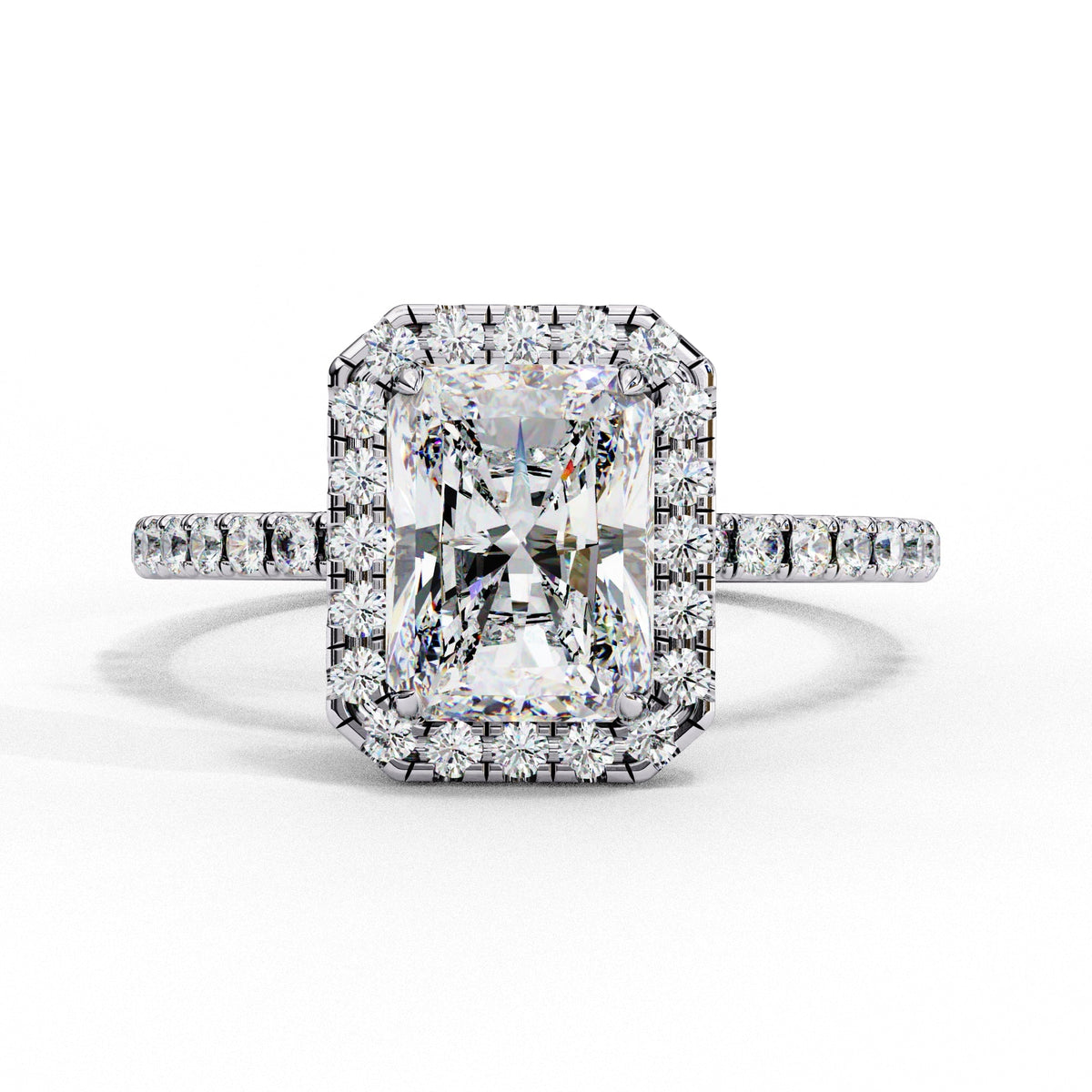 Radiant cut halo engagement ring with round side stones in white gold metal.