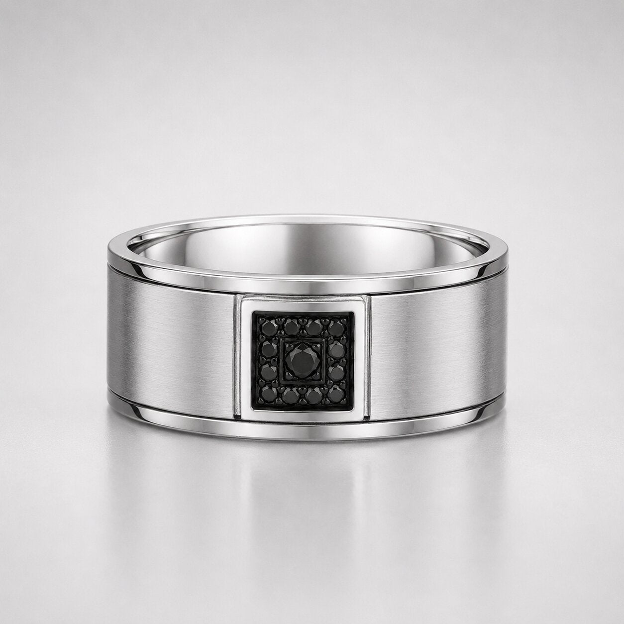 Round cut black diamond men's wedding band featuring a brushed white gold band with a square black diamond cluster centerpiece.