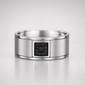 Silver ring with a black gemstone on a light gray background
