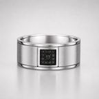 Silver ring with a black gemstone on a light gray background