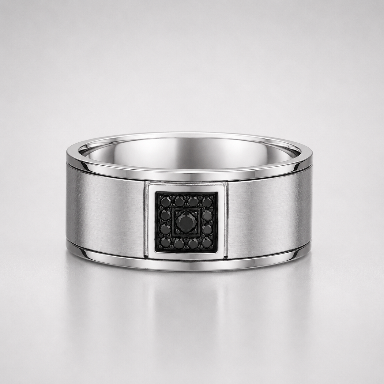 Silver ring with a black gemstone on a light gray background