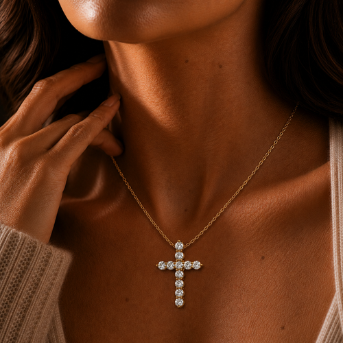 Close-up of a person wearing a gold cross necklace with a blurred background