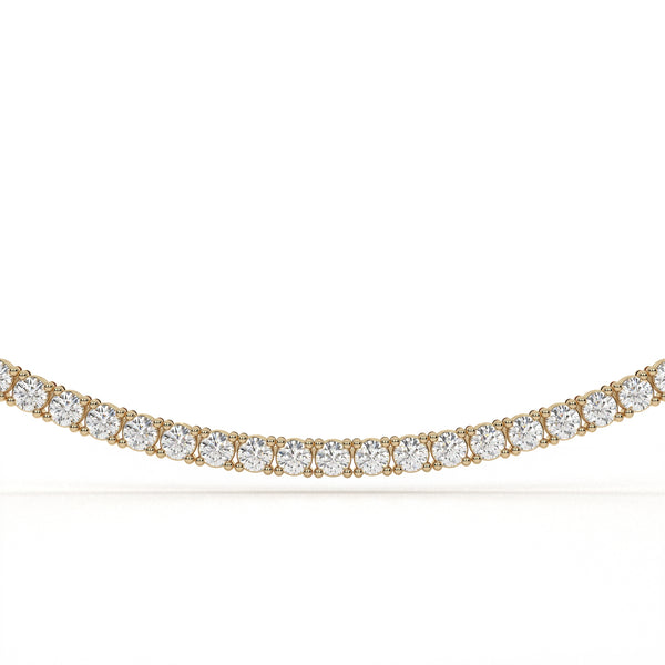 Gold necklace with clear gemstones on a white background