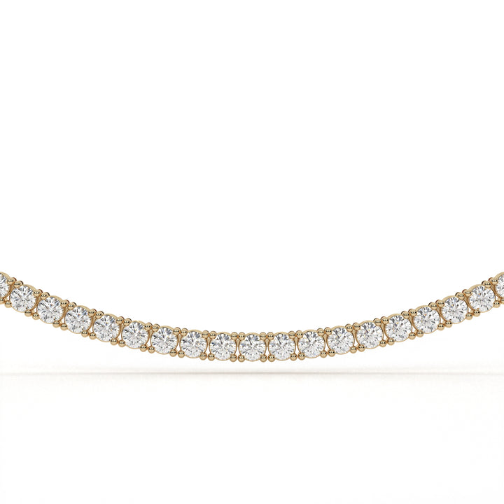 Gold necklace with clear gemstones on a white background