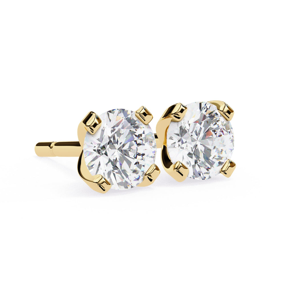 Gold stud earrings with clear gemstones on a white background