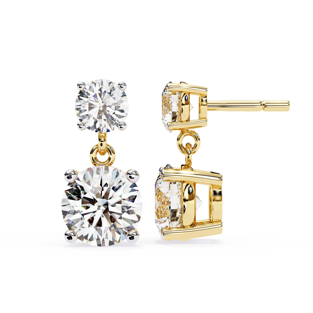 Gold earrings with large clear gemstones on a white background