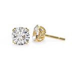 Gold stud earrings with clear gemstones on a white background