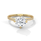 Gold ring with a large diamond and smaller diamonds on the band against a white background