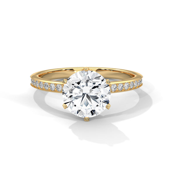 Gold ring with a large diamond and smaller diamonds on the band against a white background
