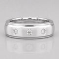 Silver ring with three diamonds on a light gray background