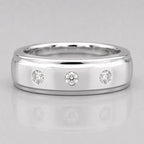 Silver ring with three diamonds on a light gray background