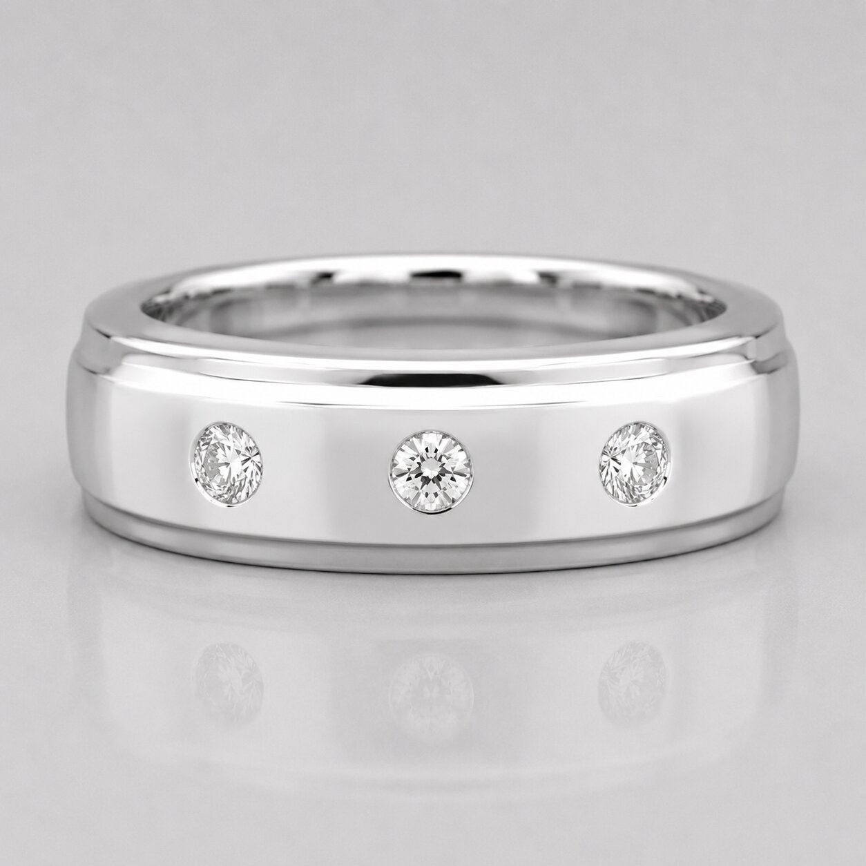 Silver ring with three diamonds on a light gray background