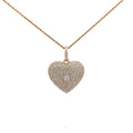 Heart-shaped diamond pendant on a gold chain against a white background