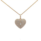Heart-shaped diamond pendant on a gold chain against a white background