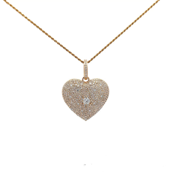 Heart-shaped diamond pendant on a gold chain against a white background