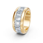 Gold ring with emerald-cut diamonds on a white background