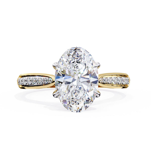 Gold ring with a large pear-shaped diamond and smaller diamonds on the band against a white background