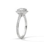 Angled side view of a cushion cut diamond halo engagement ring in white gold with a pavé diamond band and raised gallery setting.