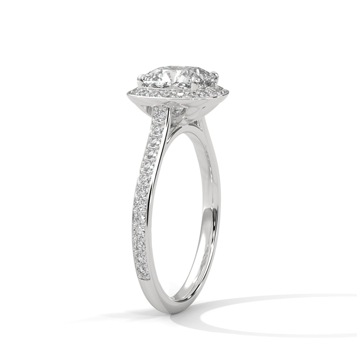 Angled side view of a cushion cut diamond halo engagement ring in white gold with a pavé diamond band and raised gallery setting.