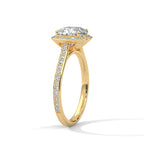 Angled side view of a cushion cut diamond halo engagement ring in yellow gold with a pavé diamond band and raised gallery setting.