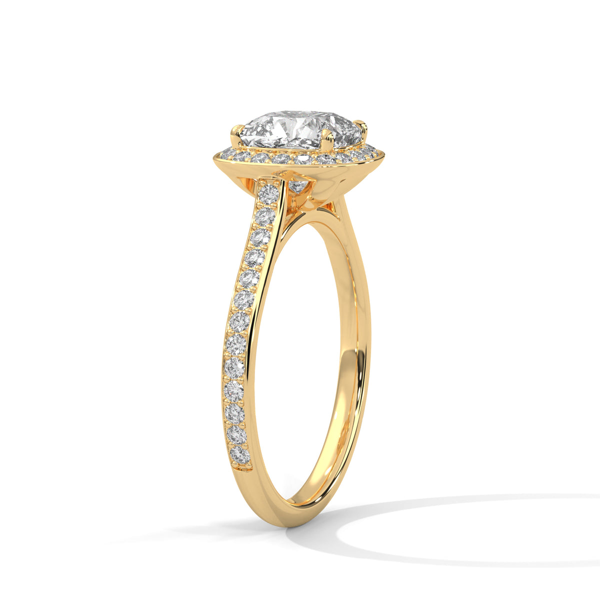 Angled side view of a cushion cut diamond halo engagement ring in yellow gold with a pavé diamond band and raised gallery setting.