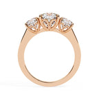 Rose gold ring with three diamonds on a white background