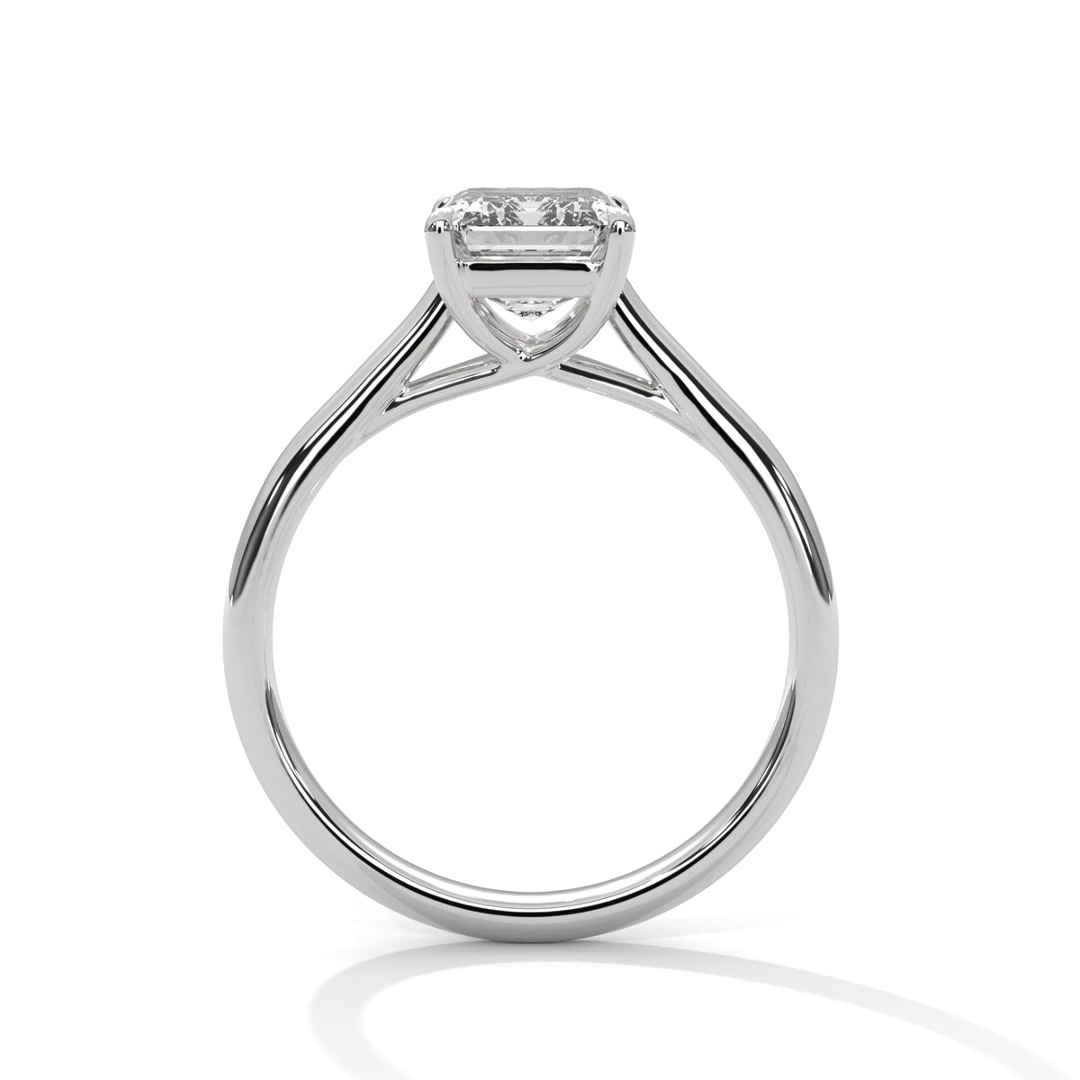 Side profile of an emerald cut diamond solitaire engagement ring in white gold with a raised four-prong setting and open gallery.