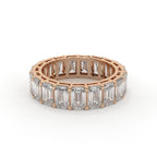 Rose gold ring with emerald-cut diamonds on a white background