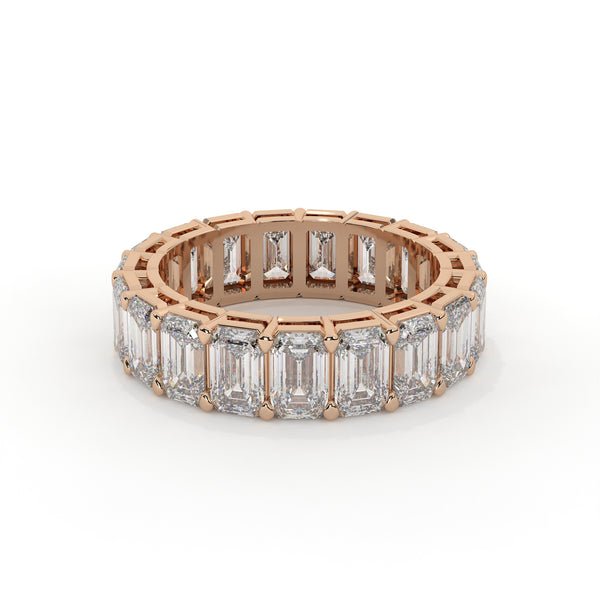 Rose gold ring with emerald-cut diamonds on a white background