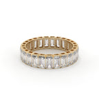 Gold ring with emerald-cut diamonds on a white background