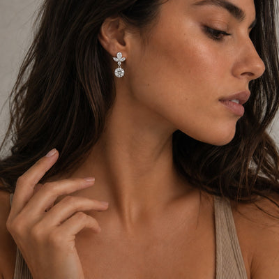 Close-up of a woman wearing elegant earrings with a neutral background