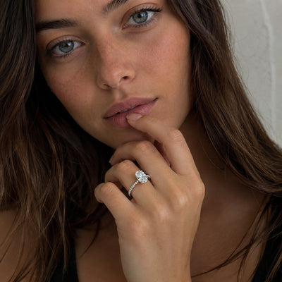 Woman wearing a diamond ring with a neutral background