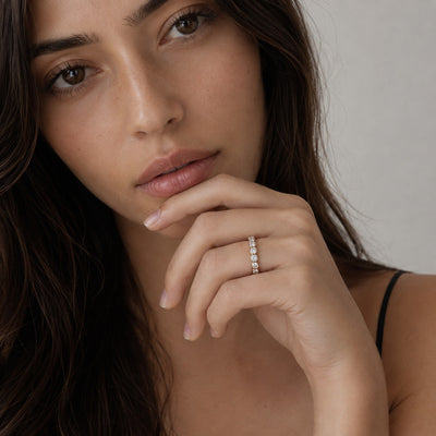 Woman wearing a diamond ring with a neutral background