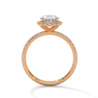 Side profile of an oval cut diamond halo engagement ring in rose gold with a pavé diamond band and raised halo setting.