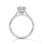 Side profile of a princess cut diamond engagement ring in white gold with a pavé diamond band, raised four-prong setting, and open gallery.