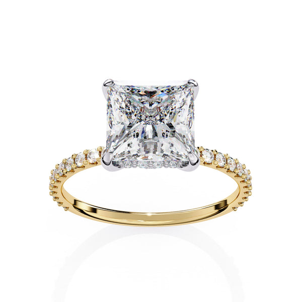 Gold ring with a large diamond and smaller diamonds on the band against a white background
