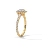 Angled side view of a round cut diamond halo engagement ring in yellow gold with a pave diamond band and diamond-accented gallery.