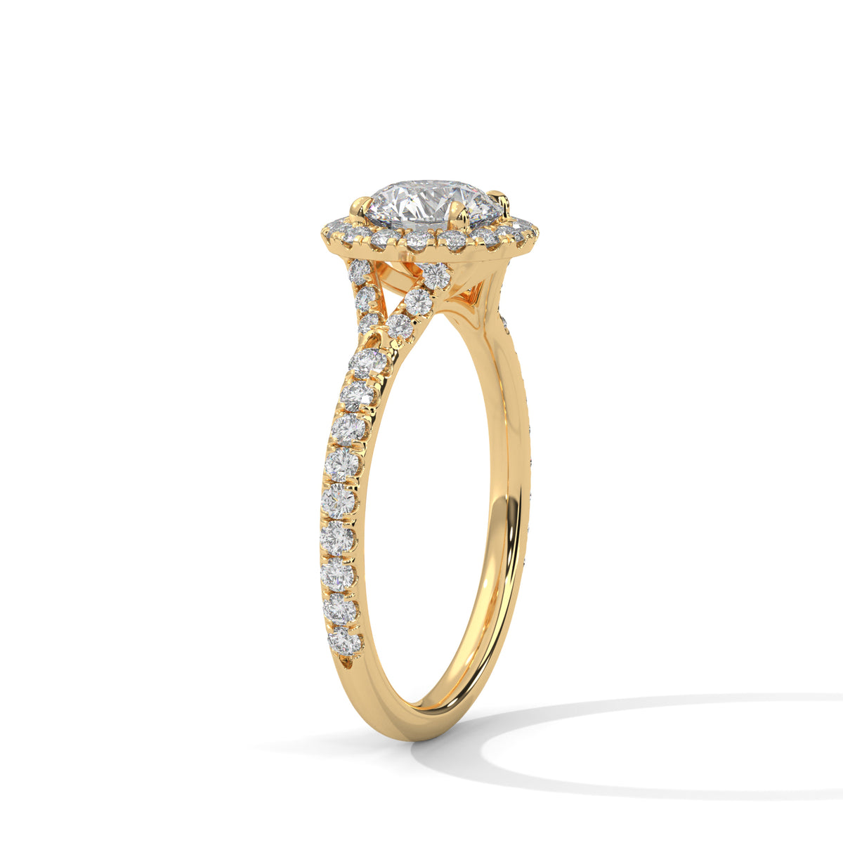 Angled side view of a round cut diamond halo engagement ring in yellow gold with a pave diamond band and diamond-accented gallery.