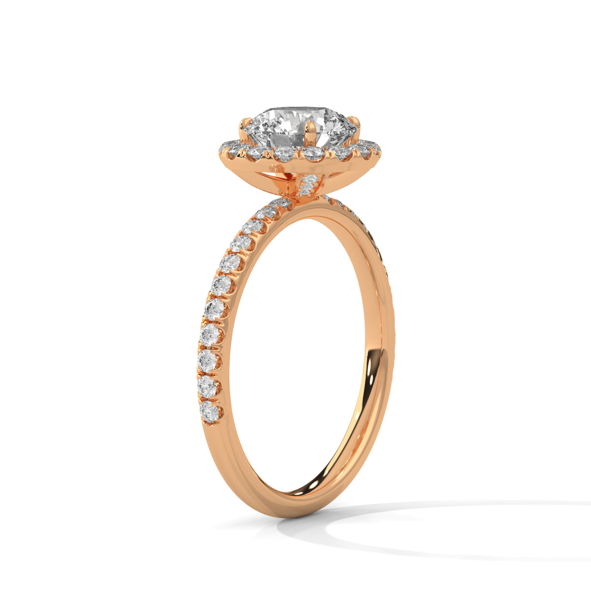 Angled side view of a round cut diamond halo engagement ring in rose gold with a pavé diamond band and raised halo setting.