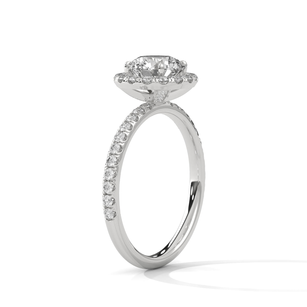 Angled side view of a round cut diamond halo engagement ring in white gold with a pavé diamond band and raised halo setting.